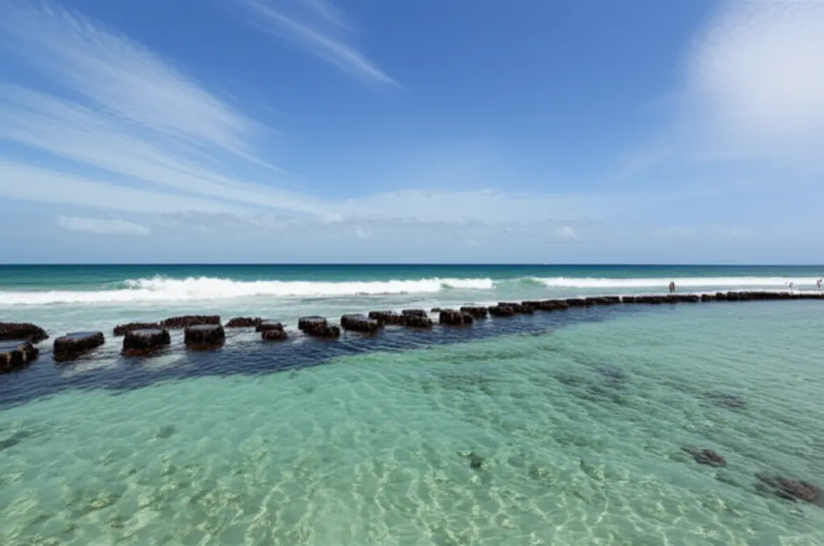 Barreira de arrecifes protegendo a praia de ondas fortes.