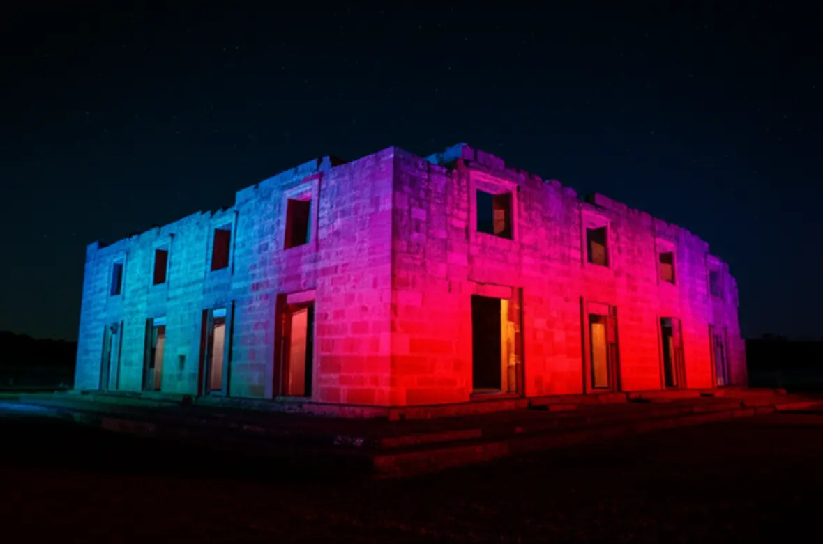 Fotografia noturna do espetáculo Som e Luz nas Ruínas de São Miguel das Missões com iluminação colorida.