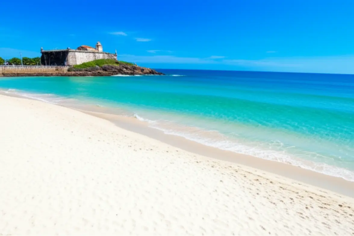 Praia do Forte em Cabo Frio com mar azul e Forte São Mateus.