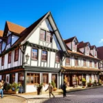 Vista frontal da arquitetura enxaimel e rua em Vila Capivari, Campos do Jordão.