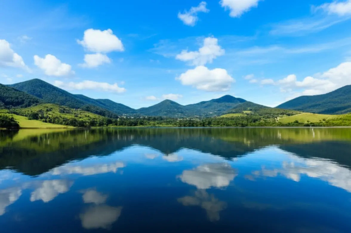 Vista do lago da Granja Comary com o reflexo das montanhas na água calma.