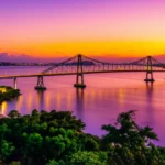 Ponte Hercílio Luz iluminada ao pôr do sol em Florianópolis.