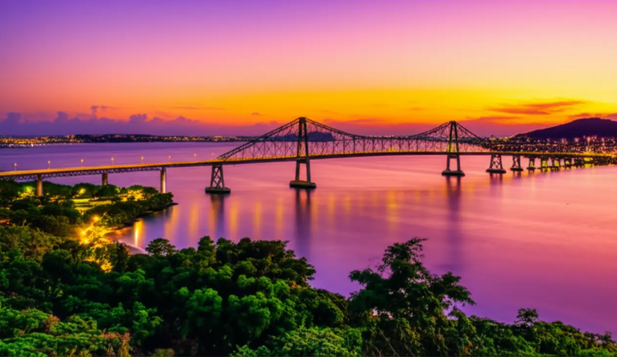 Ponte Hercílio Luz iluminada ao pôr do sol em Florianópolis.