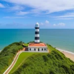 Farol das Conchas no topo do morro com vista para a praia e o mar azul na Ilha do Mel.