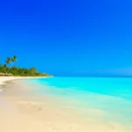 Panorama deslumbrante de uma praia em Aruba com mar azul e areia fina.