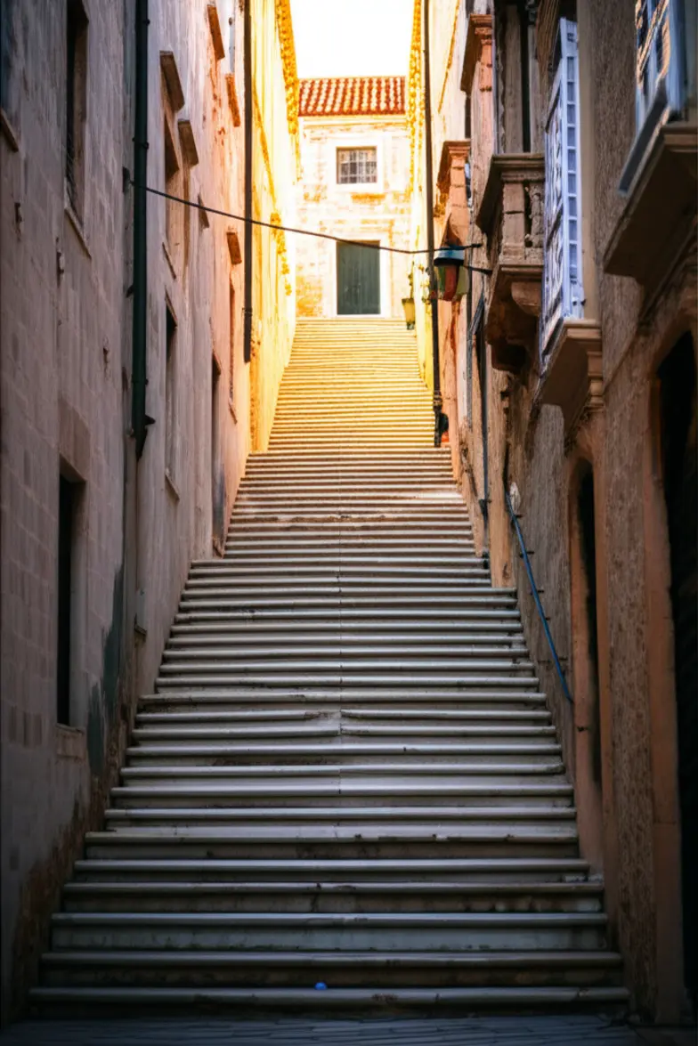 Escadaria de pedra barroca em Dubrovnik, cenário histórico e cinematográfico na Croácia.