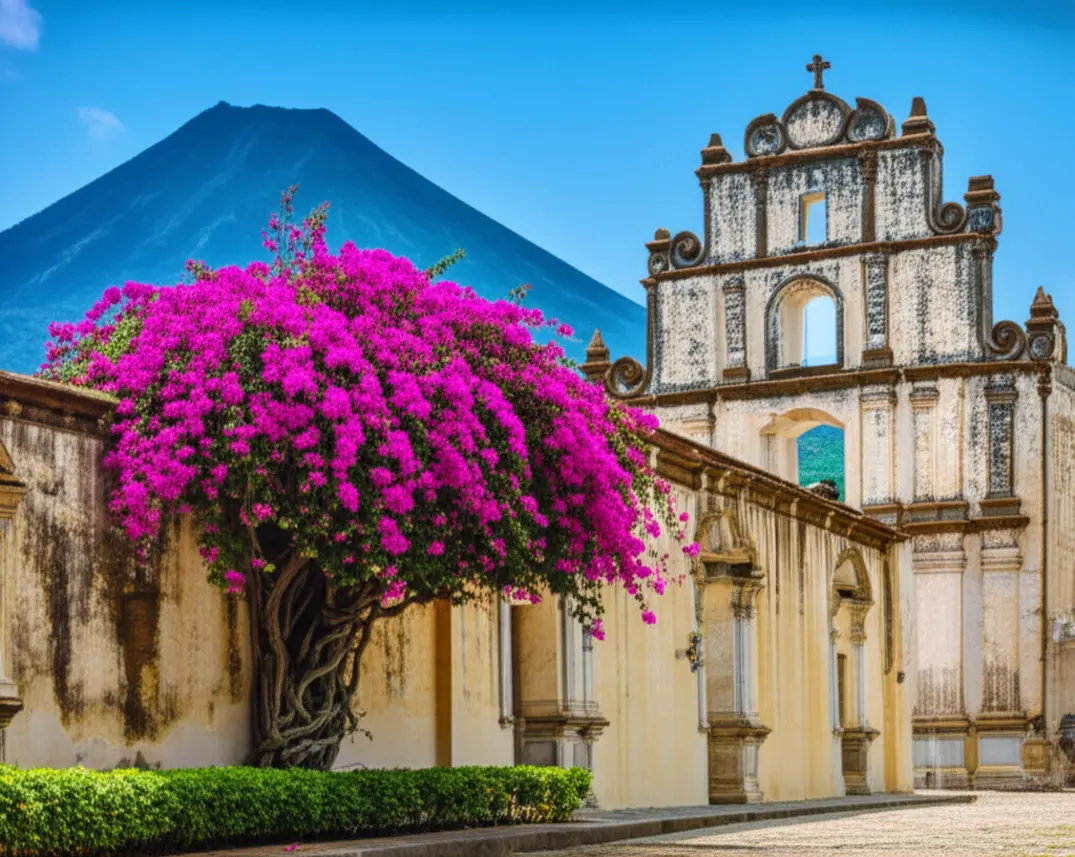 Ruínas de uma igreja colonial em Antigua Guatemala com buganvílias e vulcão ao fundo.