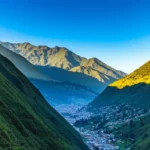 Vista aérea panorâmica da cidade de Baños cercada por montanhas verdes.