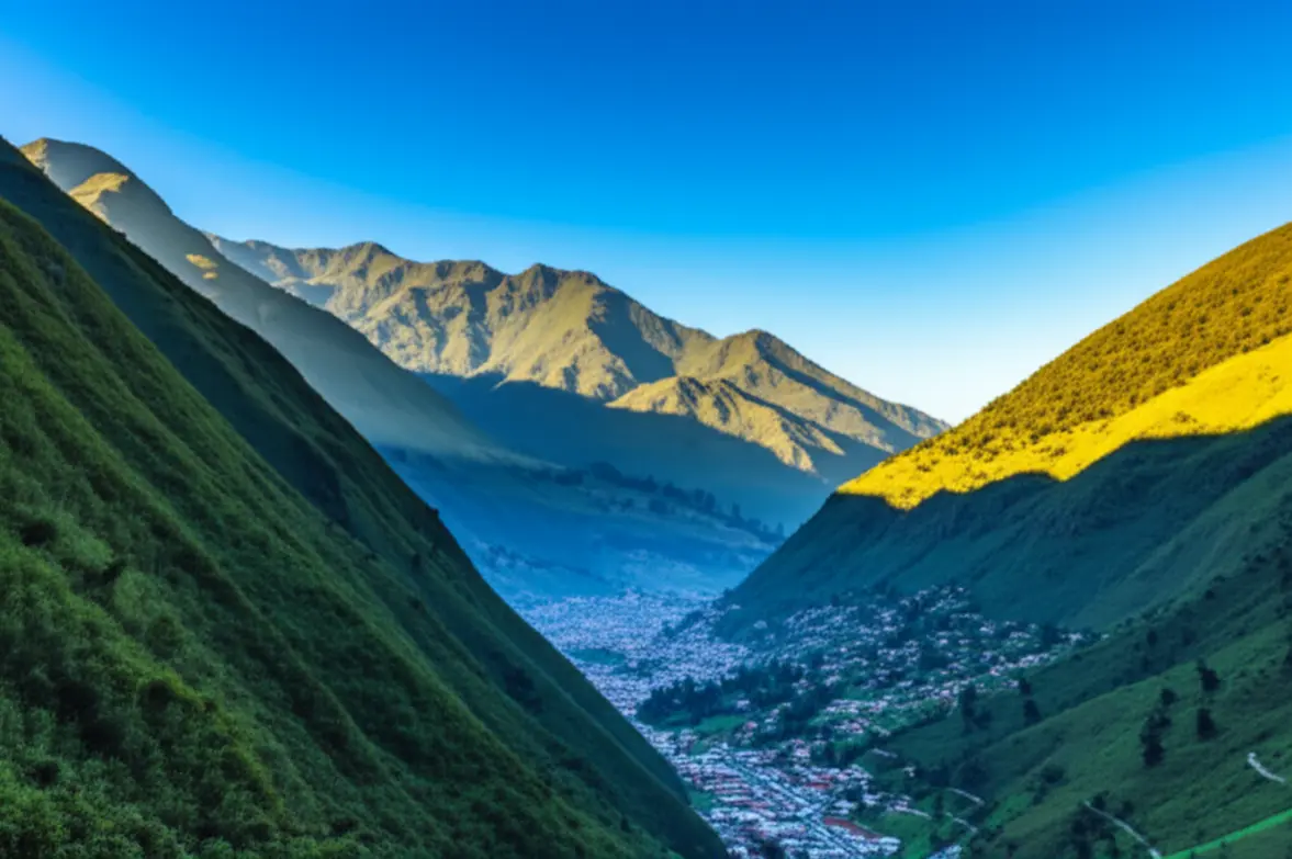 Vista aérea panorâmica da cidade de Baños cercada por montanhas verdes.