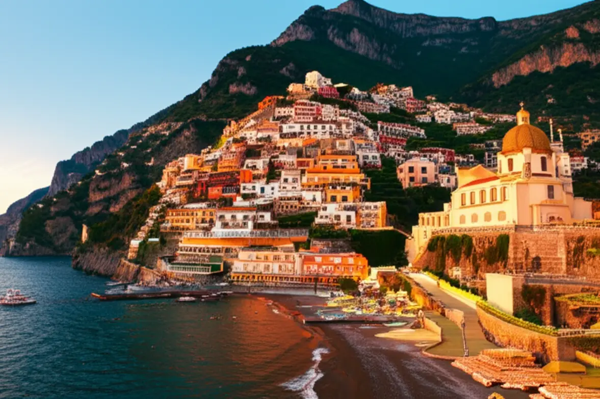 Vista clássica de Positano com suas casas coloridas e cúpula da igreja sob o pôr do sol.