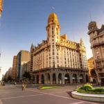 Fachada do Palacio Salvo e Plaza Independencia em Montevidéu durante o pôr do sol.