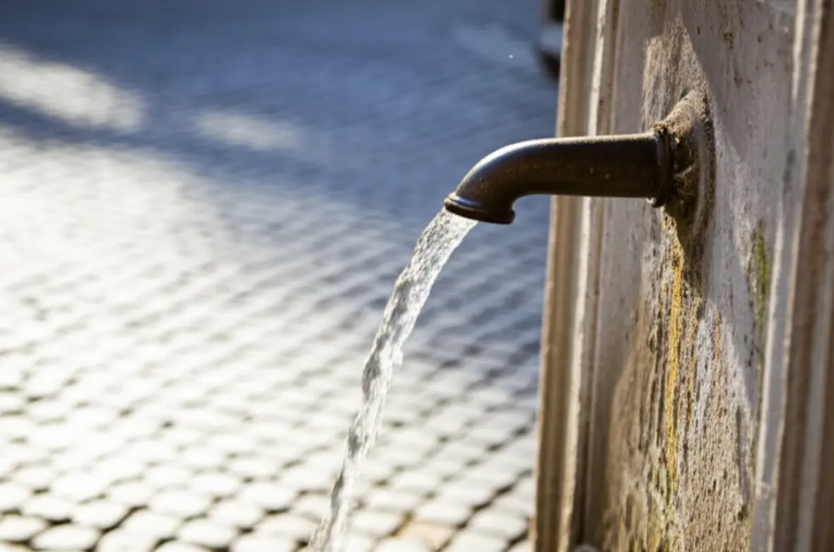 Detalhe de uma fonte de água pública Nasone em uma rua de Roma.