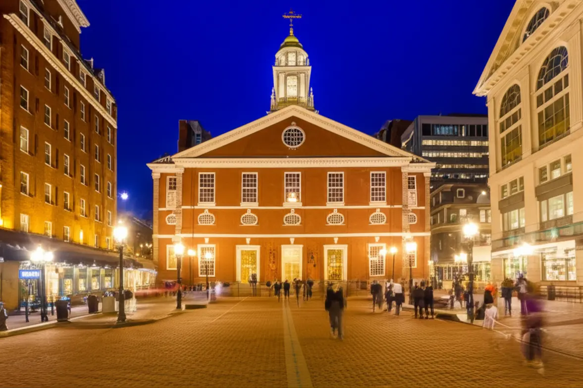 O mercado Quincy Market iluminado à noite, mostrando um ambiente seguro e convidativo.