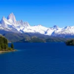 Paisagem de Bariloche com lago azul e montanhas cobertas de neve ao fundo.