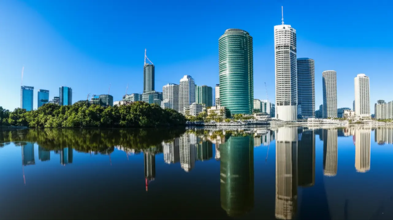 Skyline de Brisbane com prédios modernos e o Rio Brisbane sob um pôr do sol dourado.