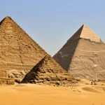 As Grandes Pirâmides de Gizé no Cairo sob um céu de pôr do sol.