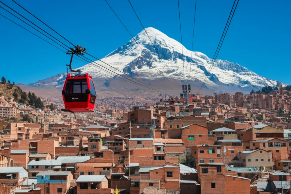 Vista aérea da cidade de La Paz com teleférico vermelho e a montanha Illimani ao fundo.