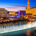 Panorama da avenida principal de Las Vegas com fontes de água e réplica da Torre Eiffel.