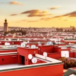 Vista panorâmica de Marraquexe ao pôr do sol com a Mesquita Koutoubia ao fundo.