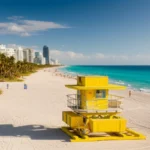 Vista aérea da praia de South Beach em Miami com mar azul e casinha de salva-vidas colorida.