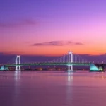A ponte Diamond Bridge (Gwangan) iluminada sobre o mar em Busan durante o pôr do sol.
