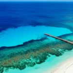 Vista panorâmica da costa de Cozumel com águas cristalinas e recifes visíveis.