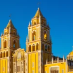 Catedral de Guadalajara com suas icônicas torres amarelas sob um céu azul.