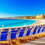 Vista panorâmica da Promenade des Anglais em Nice com mar azul e prédios históricos.