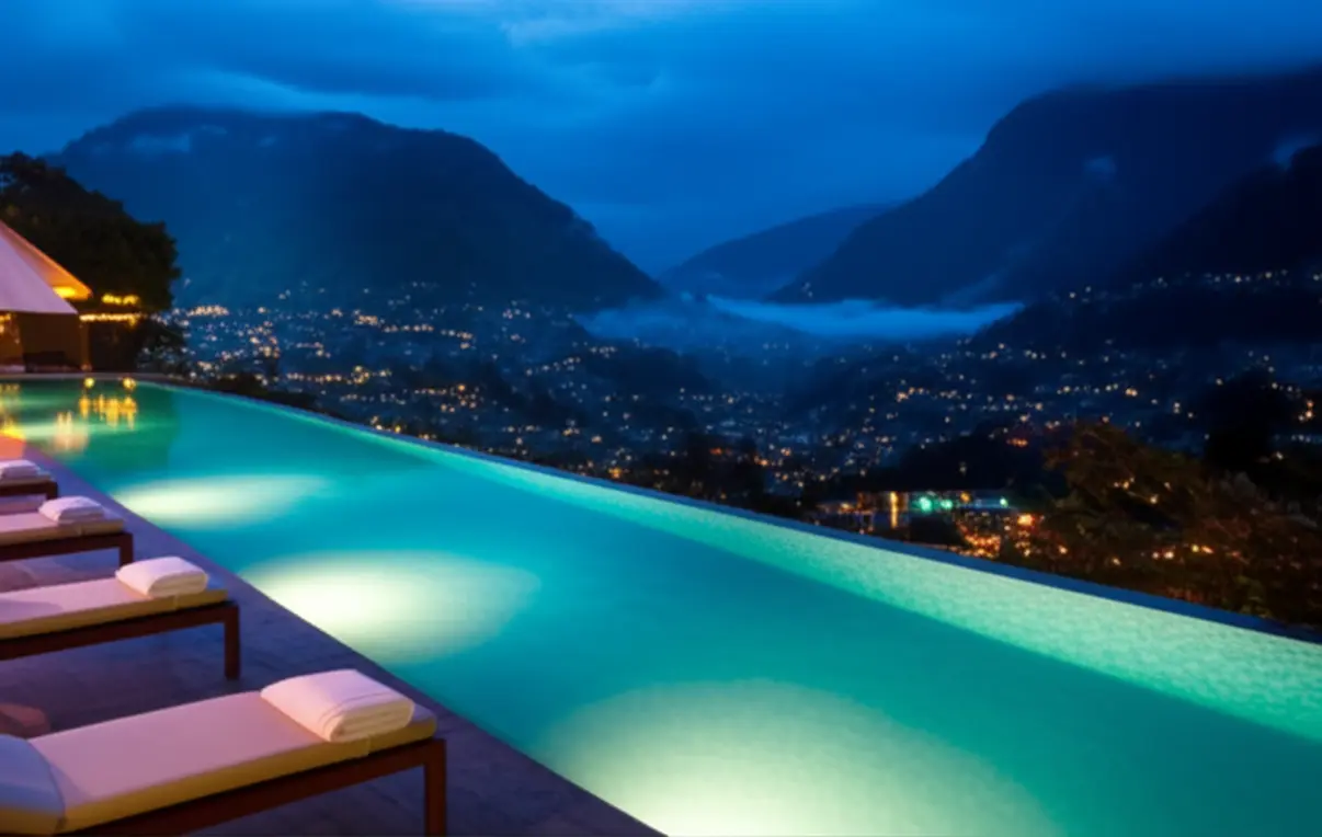 Piscina de borda infinita com vista para a cidade de Baños ao anoitecer.