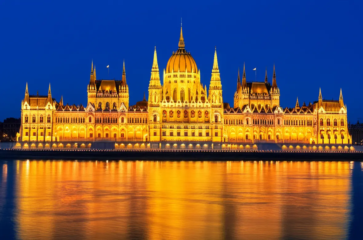 Vista panorâmica do Parlamento de Budapeste iluminado ao anoitecer.