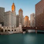 Skyline de Chicago refletido no rio durante o pôr do sol.