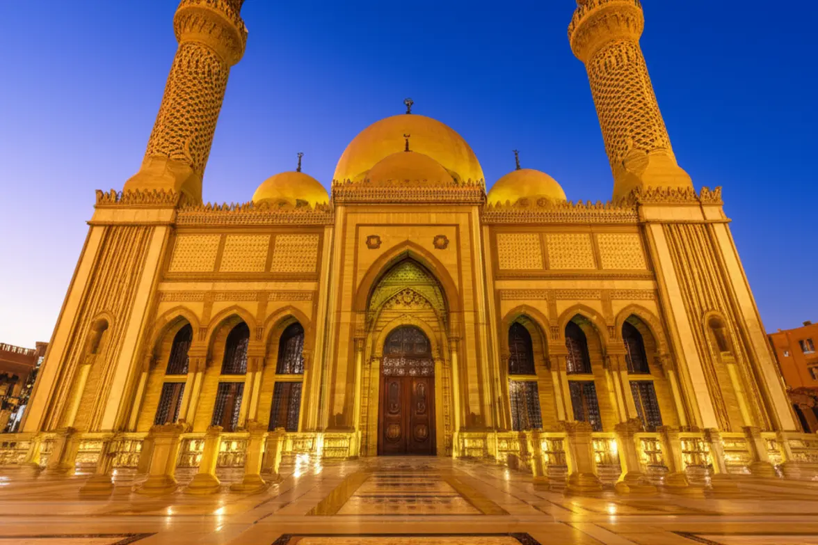 Fachada da Mesquita Al Sahaba em Sharm El Sheikh com iluminação dourada ao entardecer.