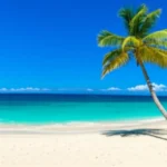 Vista panorâmica aérea da praia Doctor's Cave em Montego Bay com águas azul-turquesa.