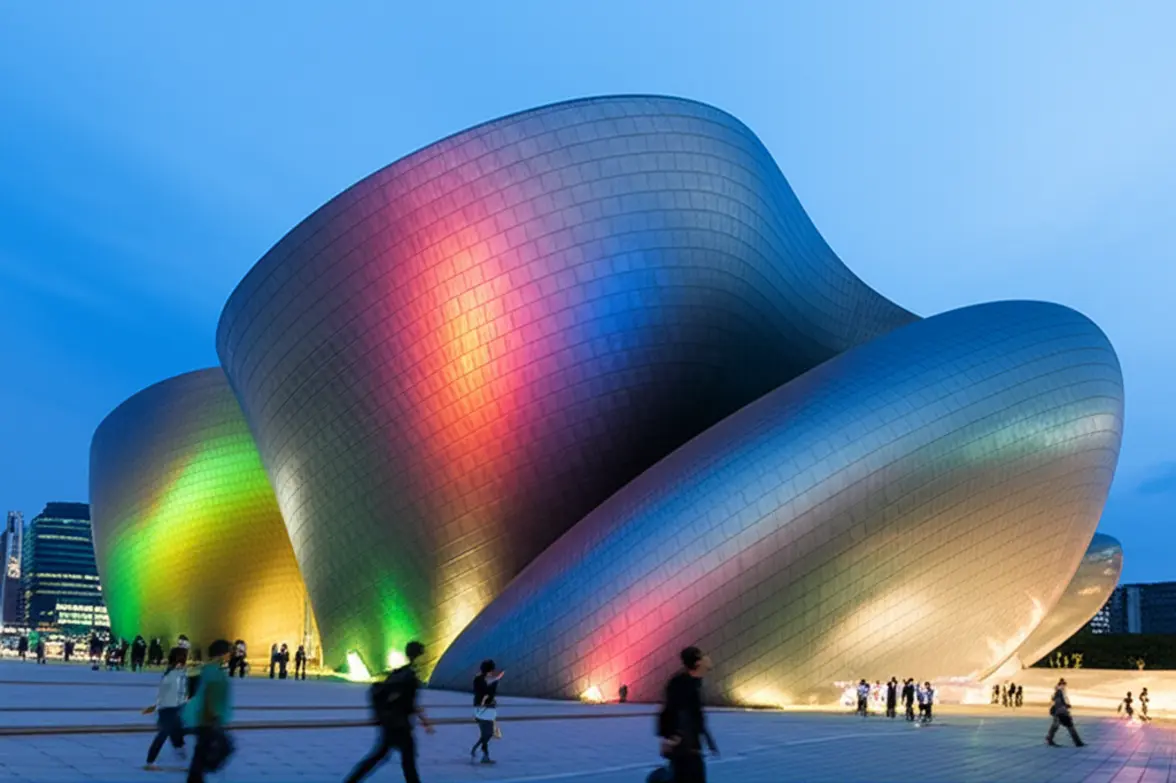 Vista externa do futurista Dongdaemun Design Plaza em Seul com luzes noturnas.