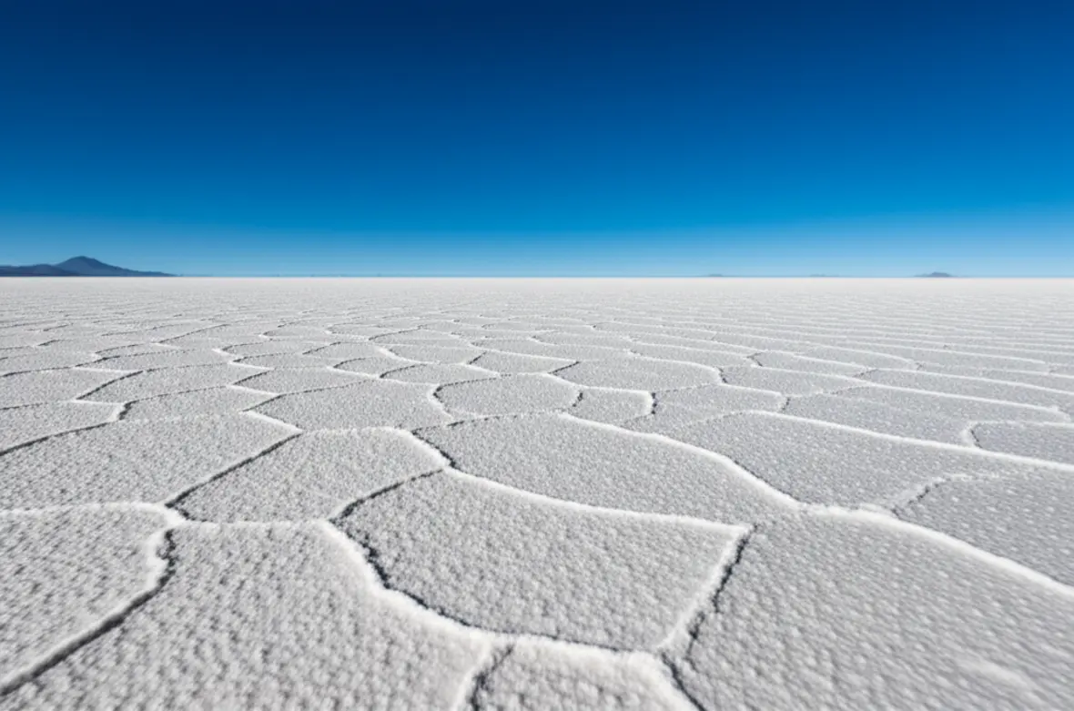 Vista panorâmica do Salar de Uyuni com suas formas geométricas de sal sob o céu azul.