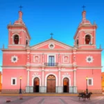 Fachada da Catedral Basílica de Salta sob uma luz dourada de pôr do sol.