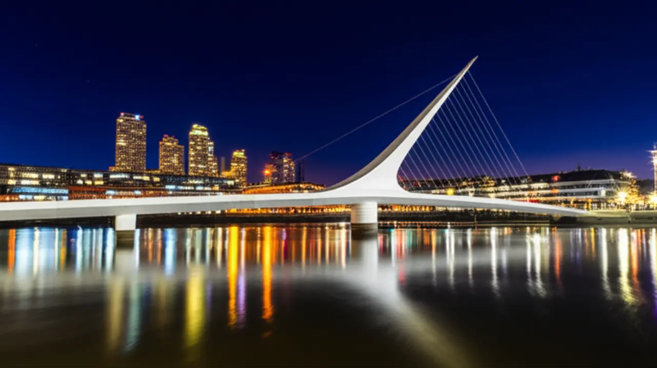 Ponte da Mulher iluminada à noite refletida nas águas de Puerto Madero, Buenos Aires.