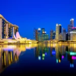 Vista panorâmica da Marina Bay em Singapura com o hotel Marina Bay Sands e o Merlion ao fundo.