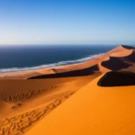 Dunas gigantes do deserto do Namibe encontrando as ondas azuis do Oceano Atlântico em Swakopmund.