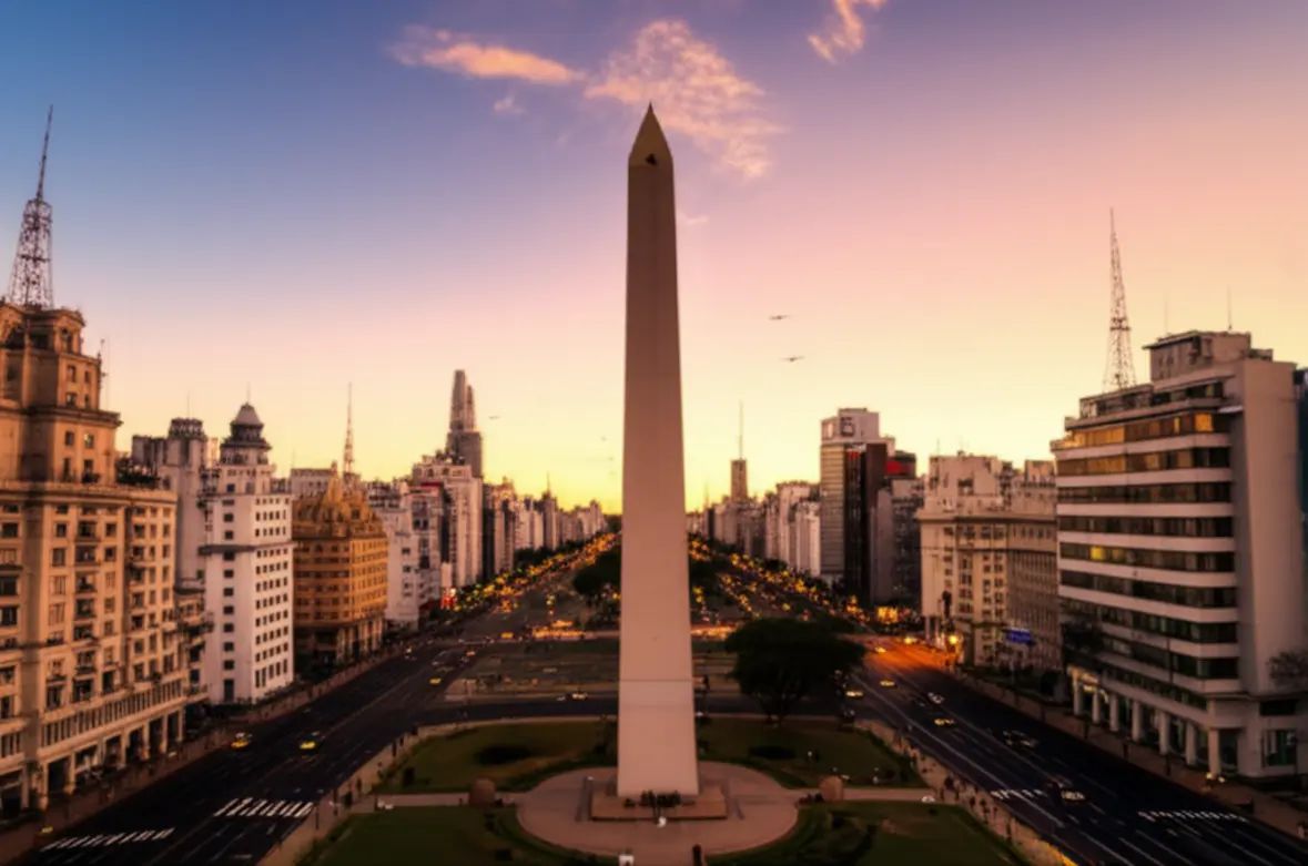 Vista panorâmica do Obelisco em Buenos Aires sob um céu dourado.