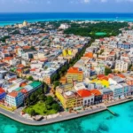 Vista aérea da ilha de Malé nas Maldivas cercada por mar azul turquesa.
