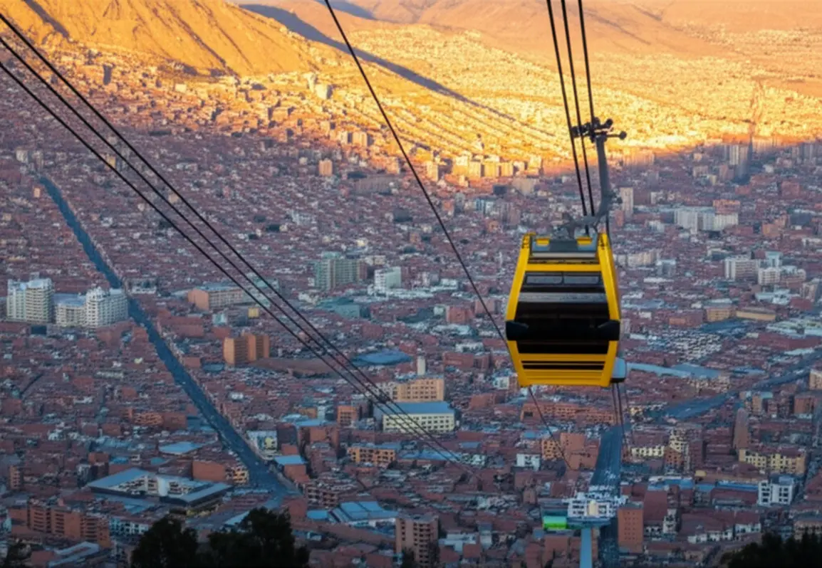 Cabine de teleférico amarela sobrevoando a bacia urbana de La Paz durante o entardecer.