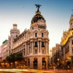 Vista panorâmica da Gran Vía em Madri com o icônico edifício Metropolis ao entardecer.